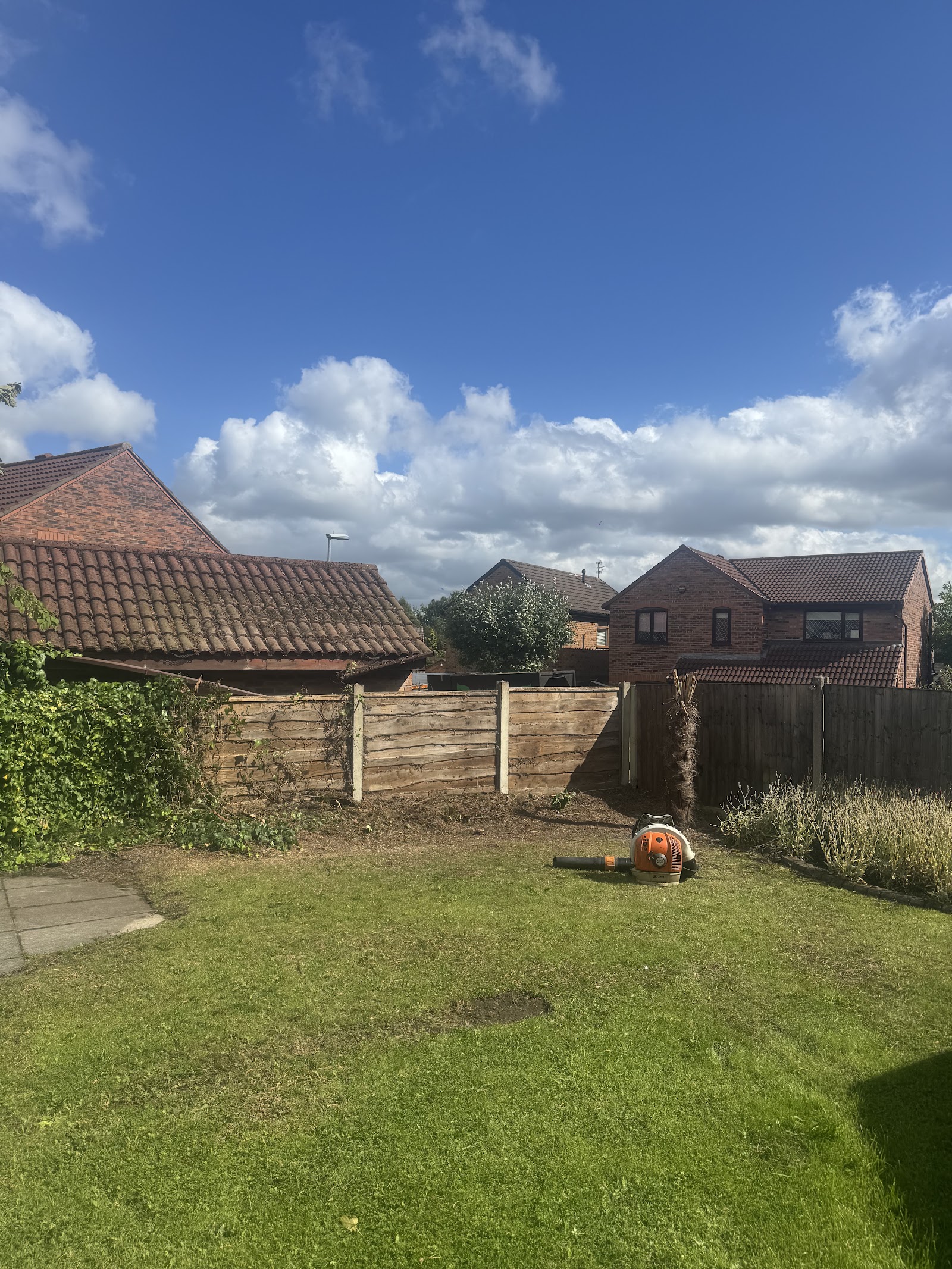A cleared and tidied back garden in Oldham after tree and shrub work, ready to use